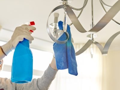 House cleaning, close-up of hands cleaning and polishing lamp